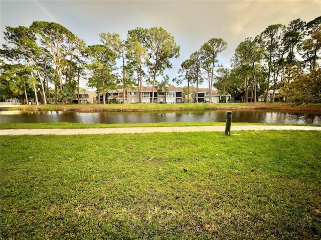 view of property's community with a water view and a yard