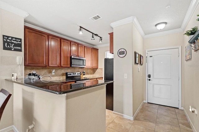 kitchen with kitchen peninsula, stainless steel appliances, backsplash, dark stone countertops, and crown molding