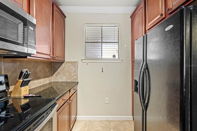 kitchen with decorative backsplash, stainless steel appliances, dark stone countertops, ornamental molding, and light tile patterned flooring