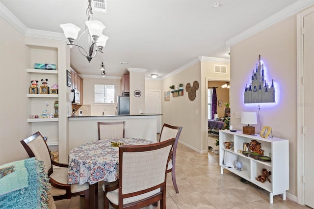 dining room with a notable chandelier, ornamental molding, and visible vents