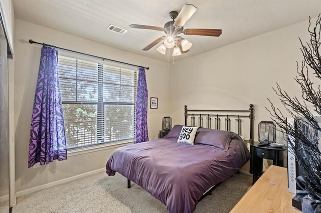 carpeted bedroom featuring visible vents, baseboards, and ceiling fan
