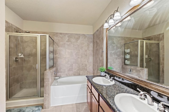 bathroom featuring vanity, shower with separate bathtub, a textured ceiling, and tile patterned flooring