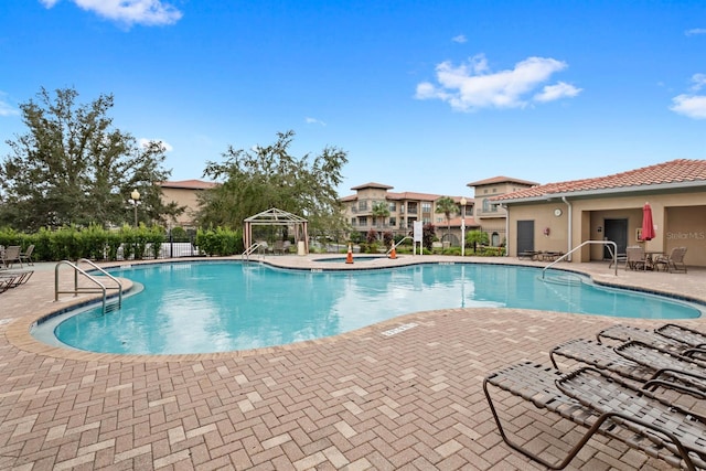 community pool featuring a gazebo, fence, and a patio