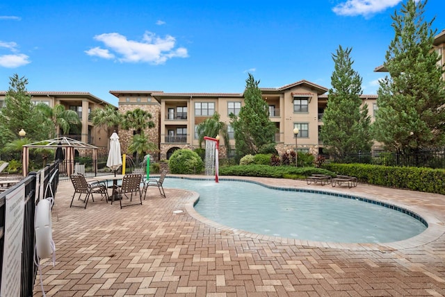 community pool featuring a patio area and fence