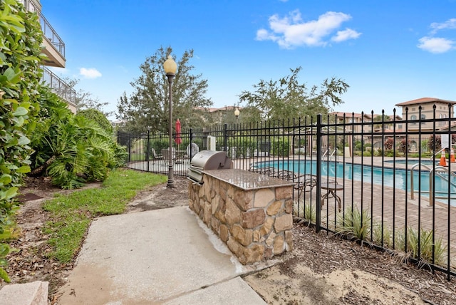 view of swimming pool featuring an outdoor kitchen and grilling area