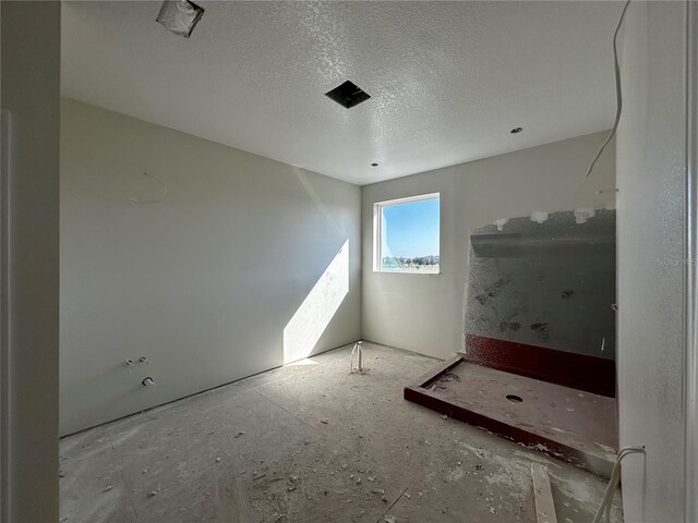 spare room with a textured ceiling