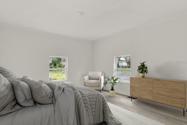 bedroom featuring ornamental molding and light hardwood / wood-style flooring