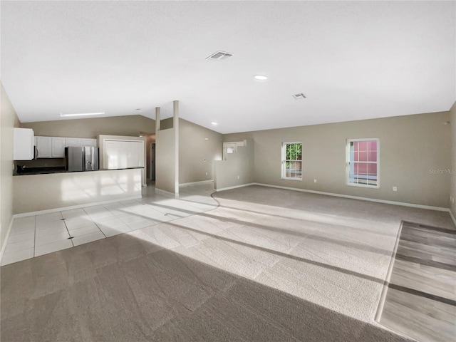 unfurnished room with lofted ceiling and light colored carpet