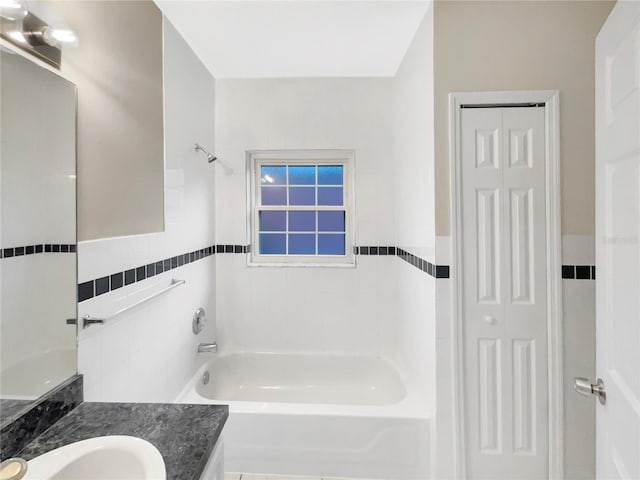 bathroom with vanity,  shower combination, and tile walls