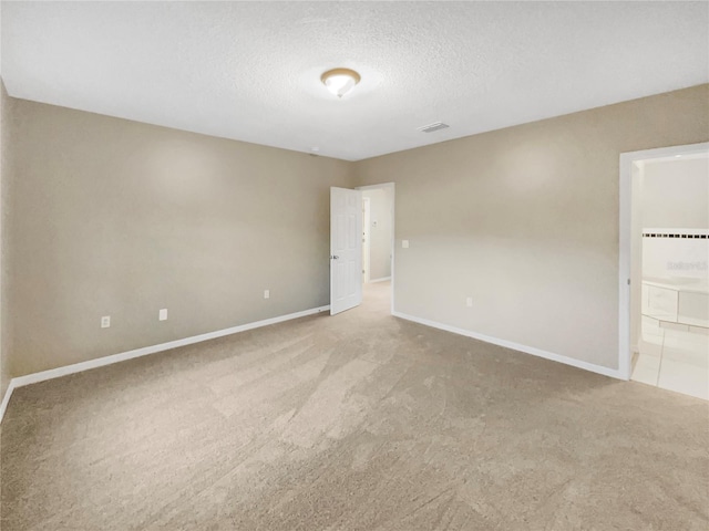 carpeted empty room with a textured ceiling