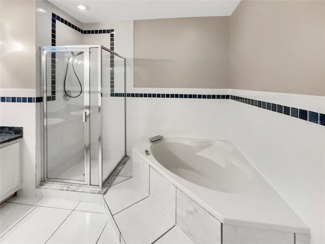 bathroom featuring tile walls, vanity, separate shower and tub, and tile patterned floors