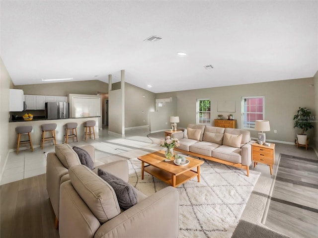 living room with vaulted ceiling and light wood-type flooring