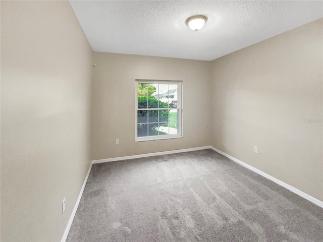 carpeted spare room with a textured ceiling