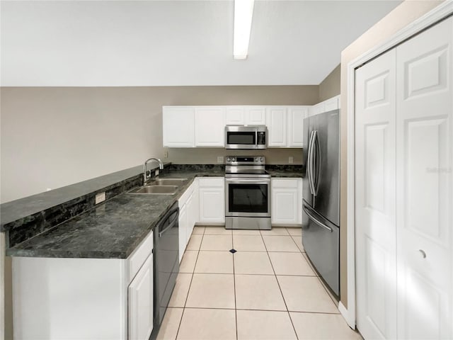 kitchen featuring sink, kitchen peninsula, white cabinetry, stainless steel appliances, and light tile patterned floors