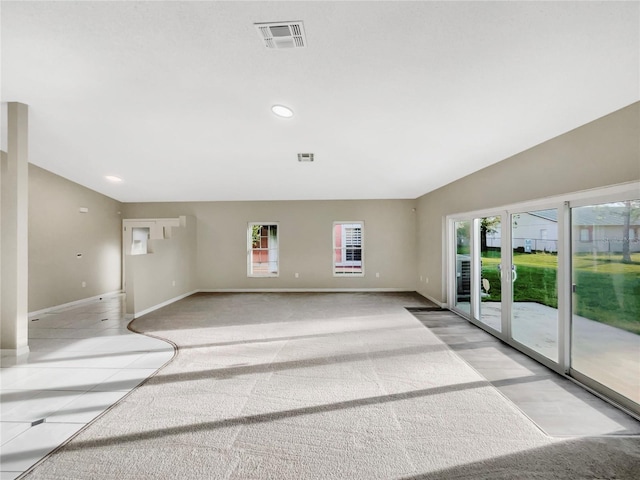 unfurnished room featuring light colored carpet, plenty of natural light, and vaulted ceiling