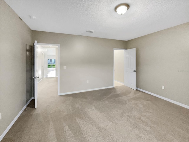 carpeted empty room with a textured ceiling