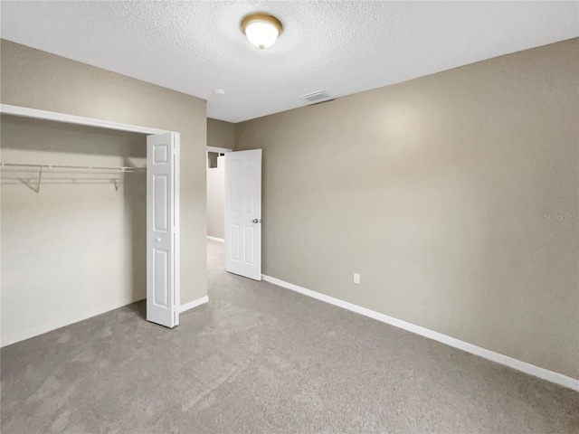 unfurnished bedroom featuring a closet, carpet, and a textured ceiling