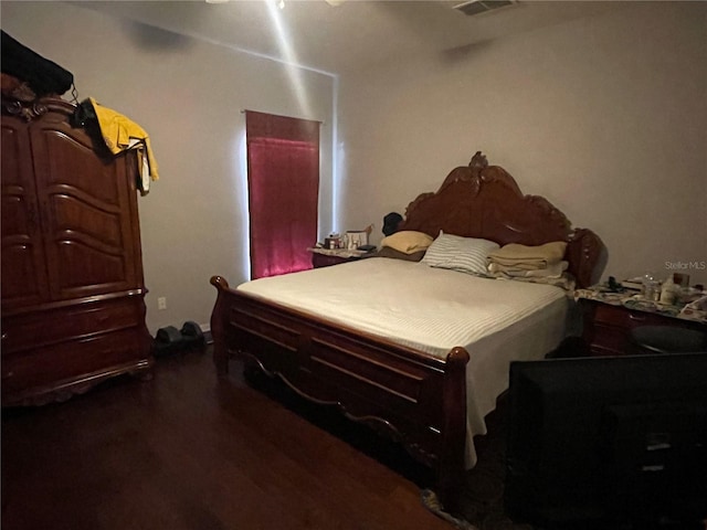 bedroom with dark hardwood / wood-style flooring