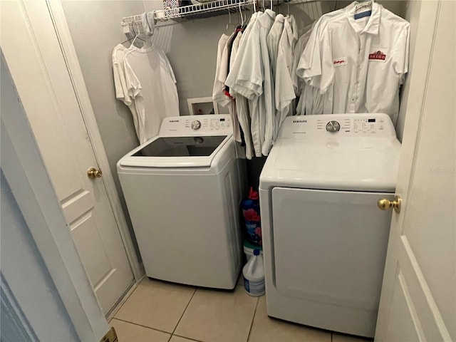 clothes washing area with washer and clothes dryer and light tile patterned floors