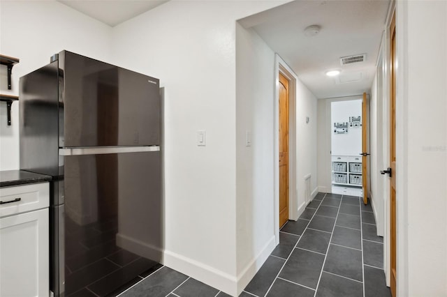 hall with dark tile patterned floors