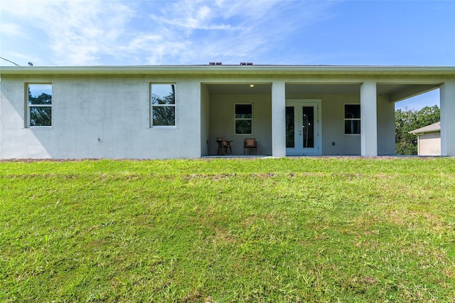 rear view of house featuring a patio and a lawn