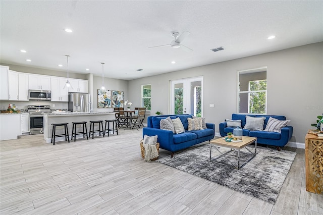 living room featuring light hardwood / wood-style flooring and ceiling fan