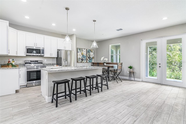 kitchen with a center island, stainless steel appliances, and white cabinetry