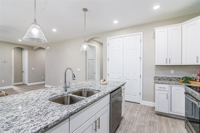 kitchen featuring white cabinets, hanging light fixtures, light stone countertops, stainless steel appliances, and sink