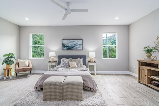 bedroom with light hardwood / wood-style flooring, ceiling fan, and multiple windows