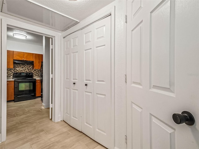 hallway featuring a textured ceiling and light hardwood / wood-style flooring