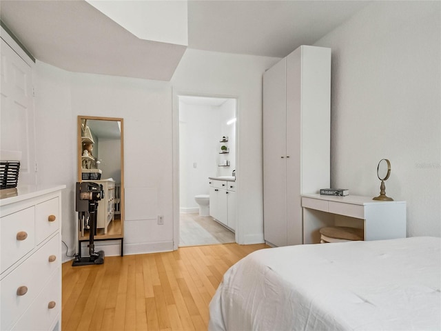 bedroom featuring light hardwood / wood-style floors and ensuite bathroom