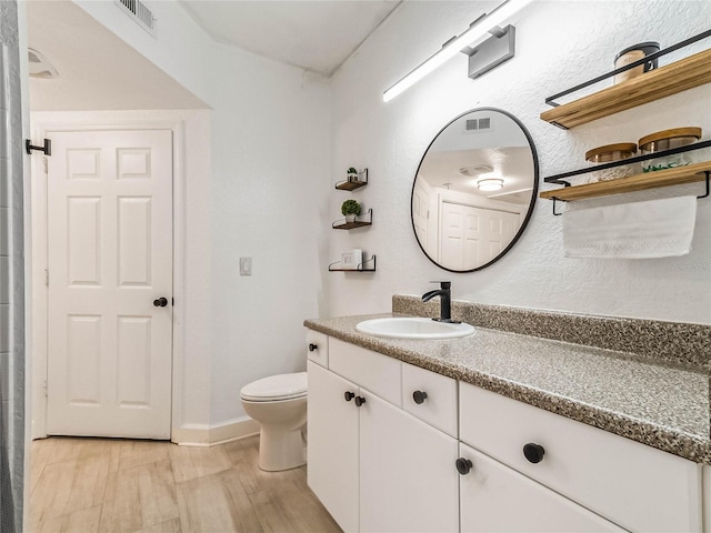 bathroom featuring vanity, hardwood / wood-style floors, and toilet