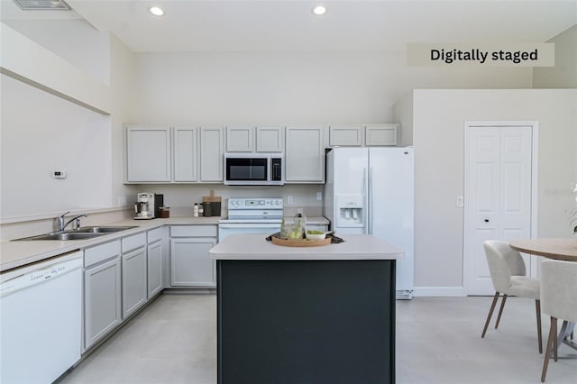 kitchen with sink, a center island, and white appliances