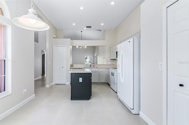 kitchen with white appliances, sink, a center island, white cabinetry, and pendant lighting