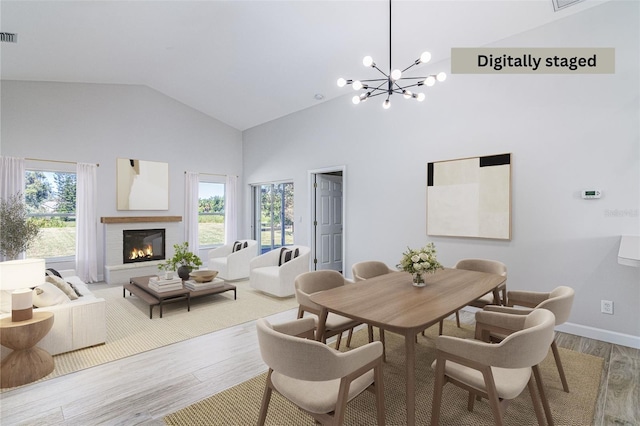 dining room featuring a wealth of natural light, wood-type flooring, and high vaulted ceiling