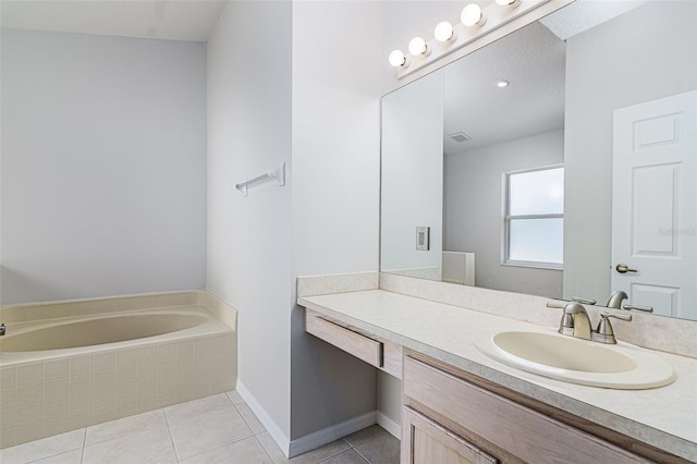 bathroom featuring vanity, tiled tub, and tile patterned flooring