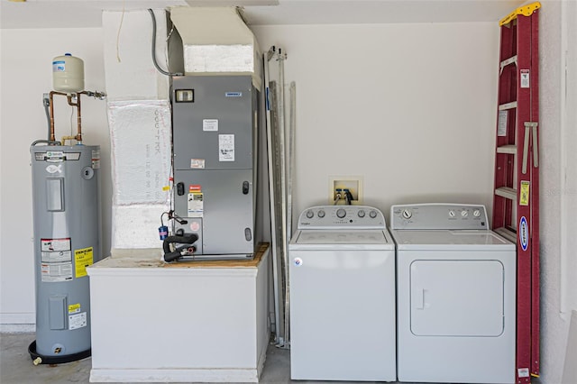 laundry room featuring water heater, heating unit, and washer and dryer