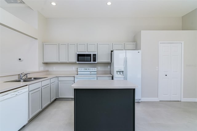 kitchen with sink, a kitchen island, and white appliances