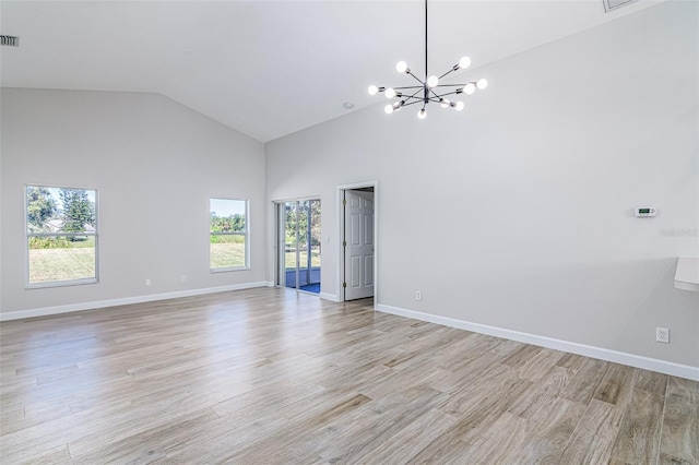 empty room featuring light hardwood / wood-style floors, high vaulted ceiling, and plenty of natural light