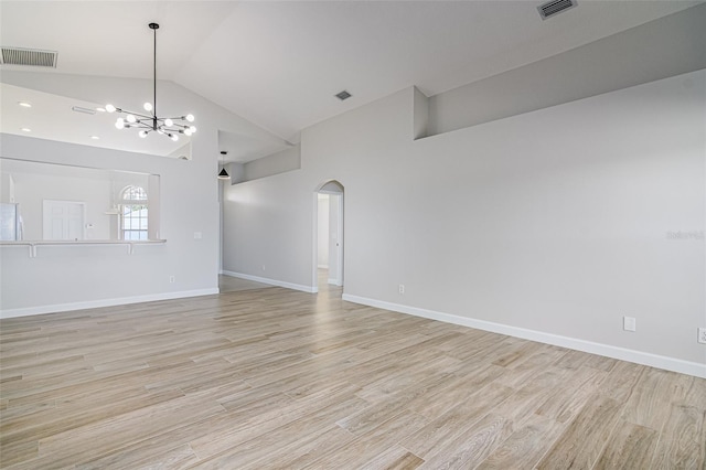 unfurnished living room featuring an inviting chandelier, high vaulted ceiling, and light hardwood / wood-style floors