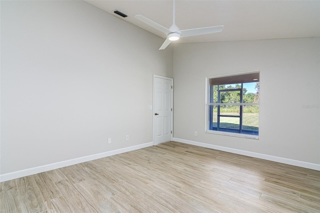 empty room featuring light hardwood / wood-style flooring, high vaulted ceiling, and ceiling fan