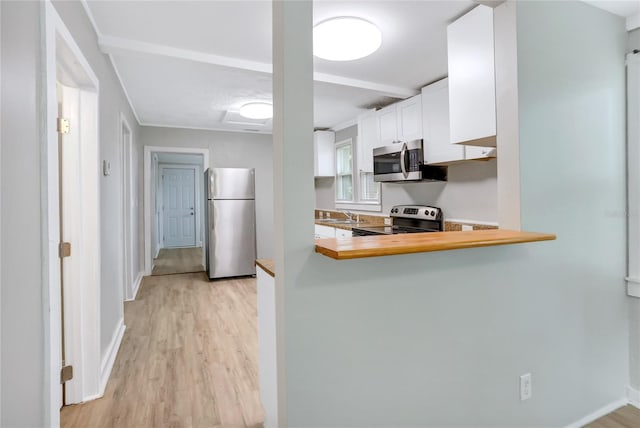 kitchen featuring kitchen peninsula, white cabinets, sink, light hardwood / wood-style floors, and stainless steel appliances