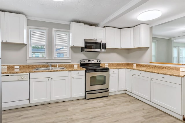 kitchen with appliances with stainless steel finishes, sink, white cabinetry, ornamental molding, and light hardwood / wood-style flooring