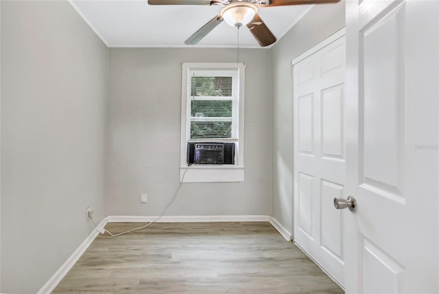 unfurnished room with ceiling fan, cooling unit, and light wood-type flooring