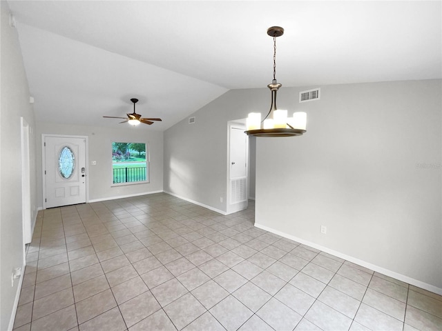 empty room with light tile patterned floors, lofted ceiling, and ceiling fan with notable chandelier