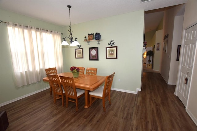 dining room featuring dark hardwood / wood-style floors and a chandelier