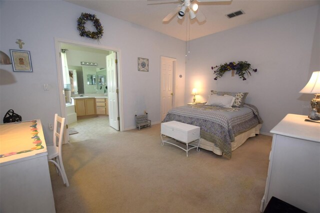 bedroom with light carpet, connected bathroom, and ceiling fan