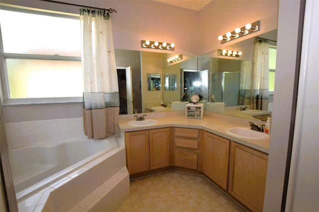 bathroom with vanity, separate shower and tub, and a healthy amount of sunlight