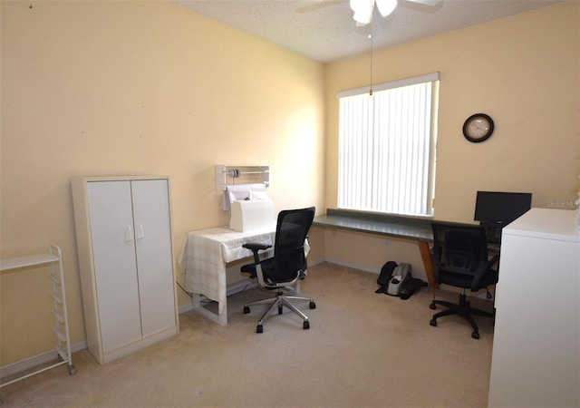 office space featuring light carpet, a textured ceiling, and ceiling fan