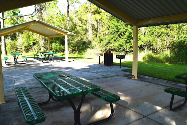 view of property's community with a patio and a lawn